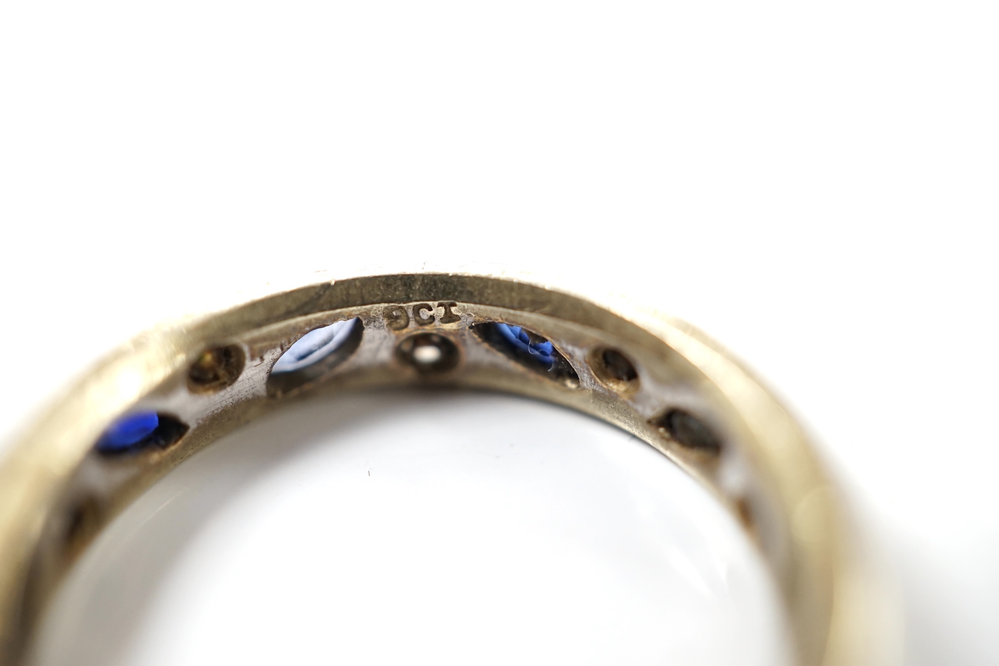 A 9ct white metal, shaped sapphire and diamond chip set eternity ring, size N, gross weight 3.7 grams. Condition - poor